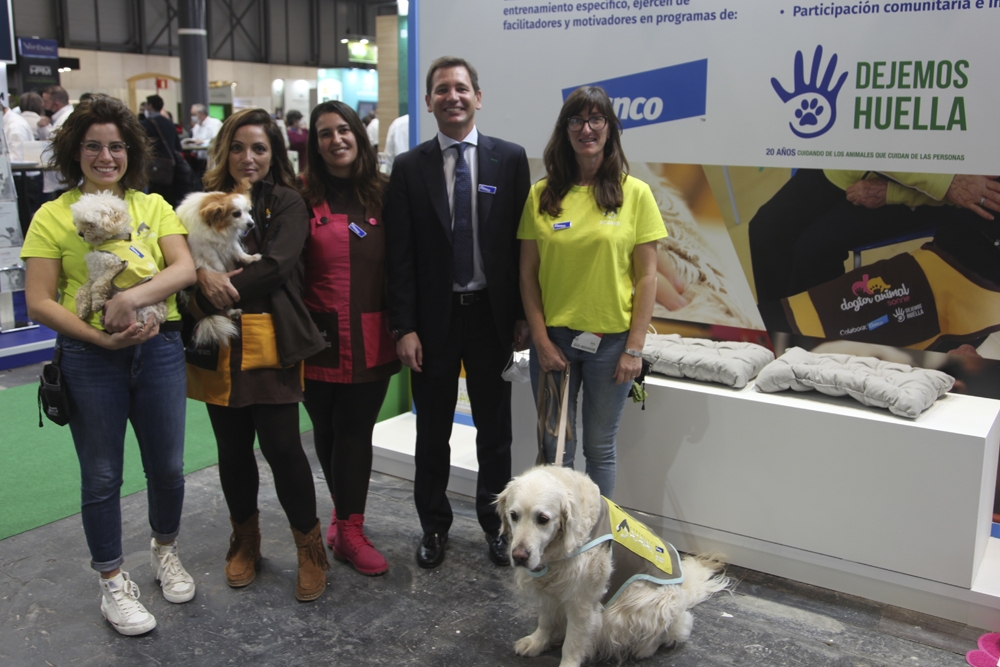 Pablo Muniesa, director general de Elanco en Iberia, junto a los perros de intervenciones asistidas con animales que estuvieron presentes en el stand.