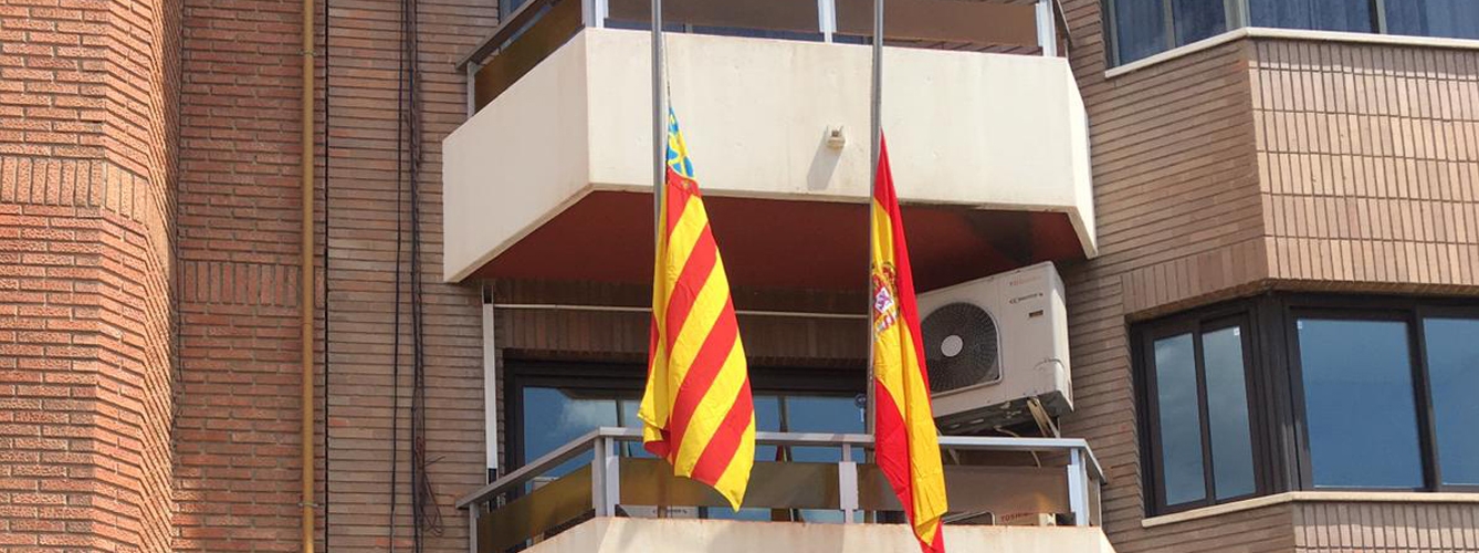 Fachada del Colegio de Veterinarios de Valencia con las banderas a media asta.