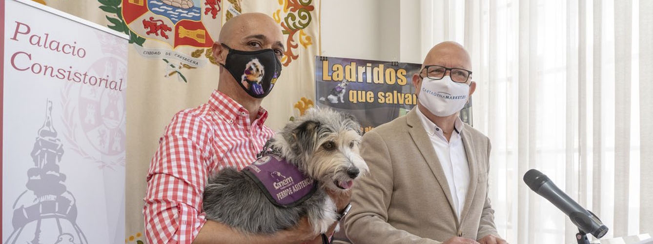 Jorge Conesa, con el perro de alerta médica Sheldon en brazos, y Manuel Padín, concejal de Sanidad de Cartagena, durante la presentación de la campaña.